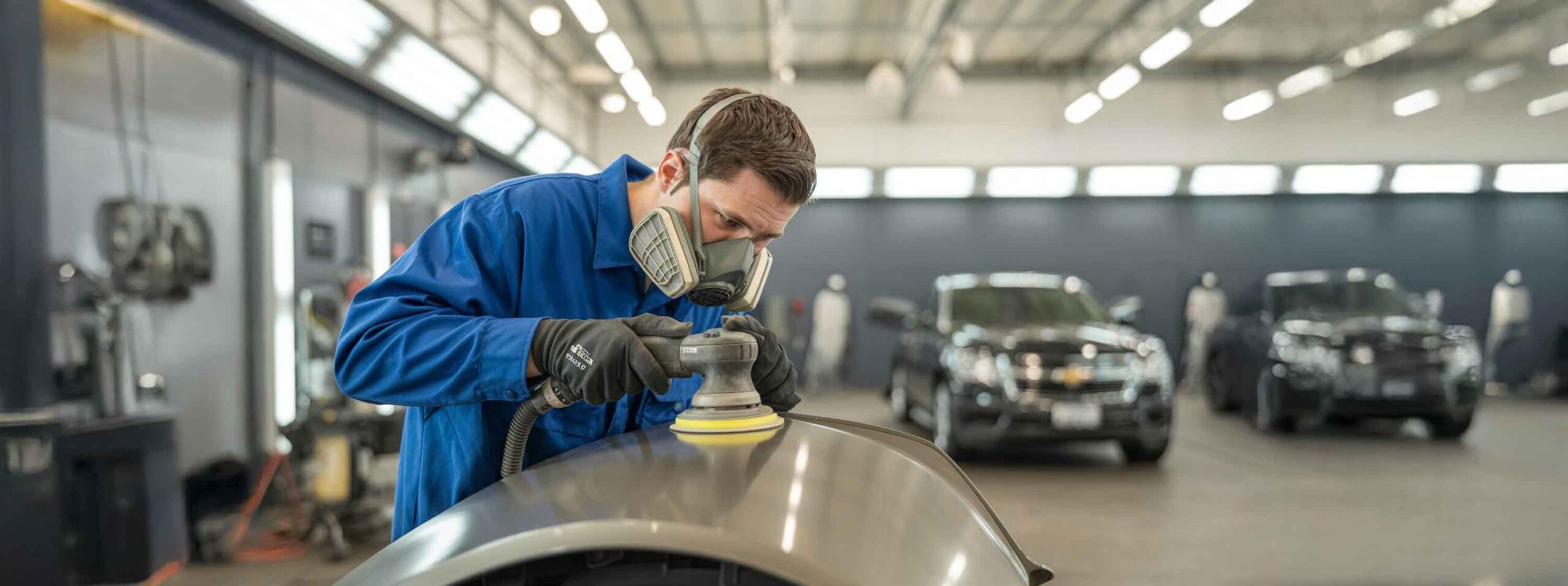 Technician sanding and prepping a panel – Chevrolet Certified Collision Center Technician sanding and prepping a panel - Chevrolet Certified Collision Center