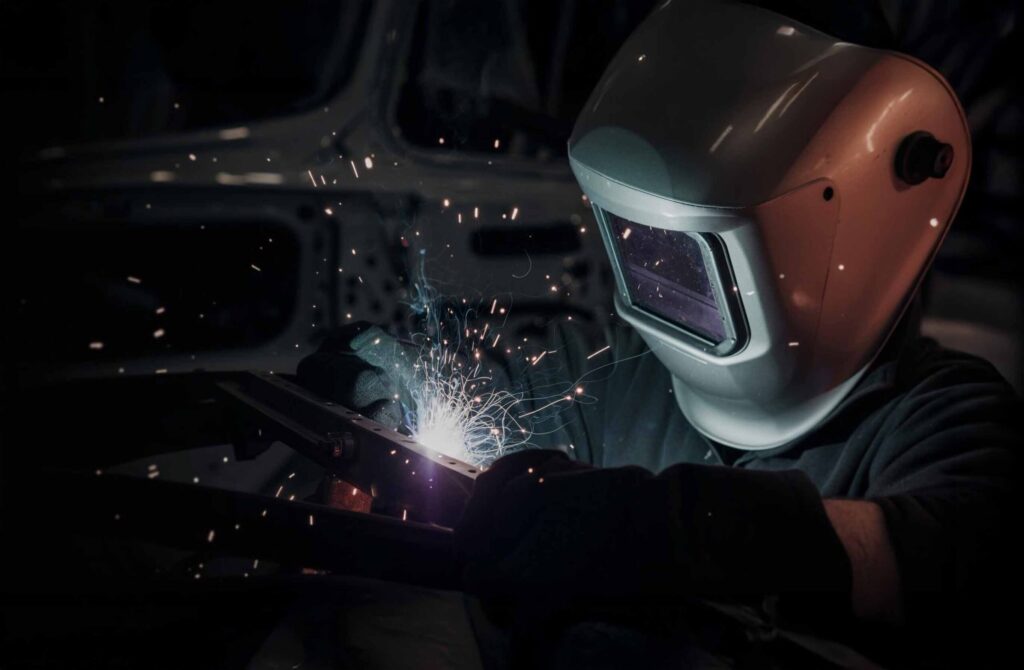 Technician wearing welding mask welding – Collision Repair Process Technician wearing welding mask welding - Collision Repair Process