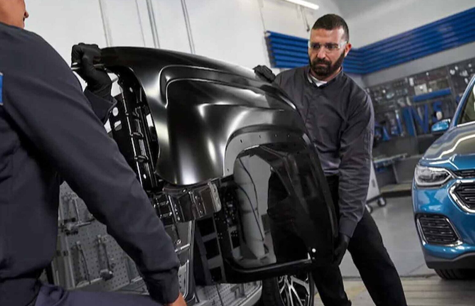 Technicians Moving Chevy Truck Bedside for Repair - Friendly Certified Collision Center